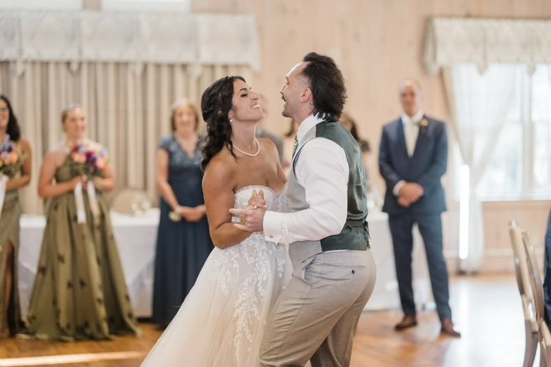 Bride and groom dancing at their wedding reception while guests watch, showcasing dances to learn for a wedding.